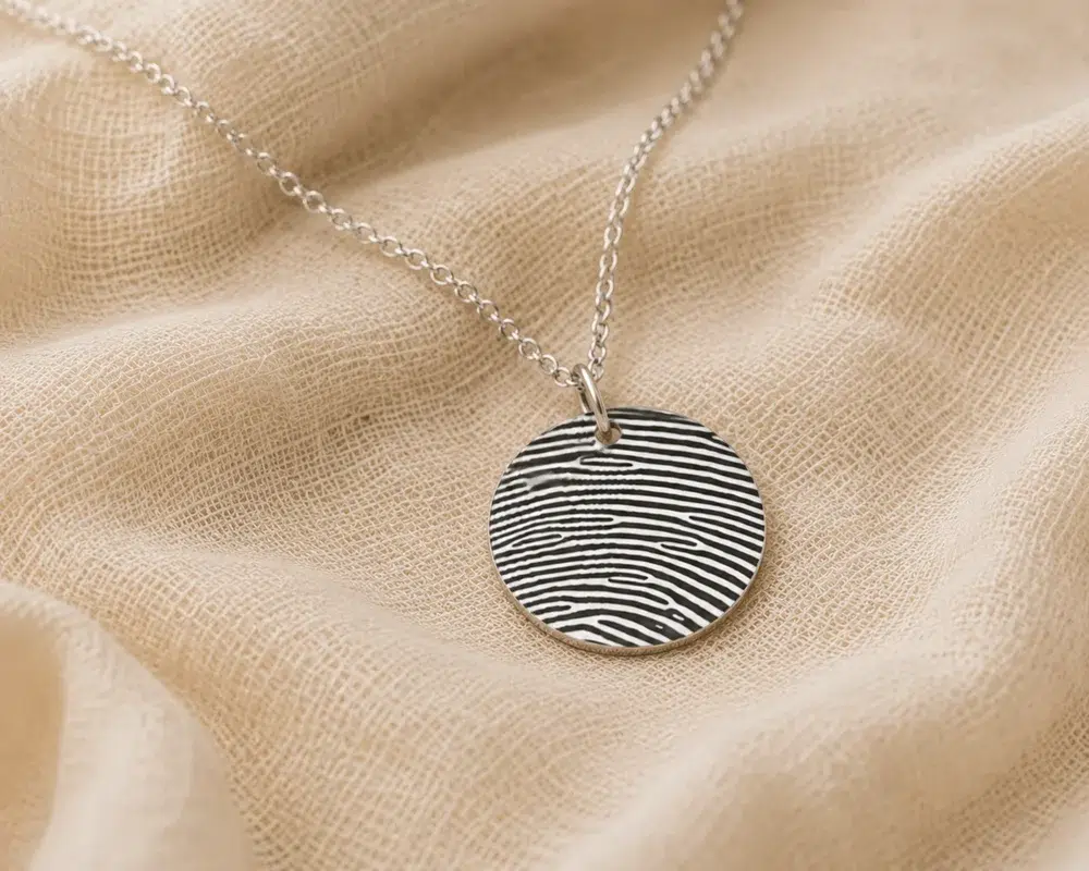 Silver disc necklace with fingerprint engraving covering the full pendant