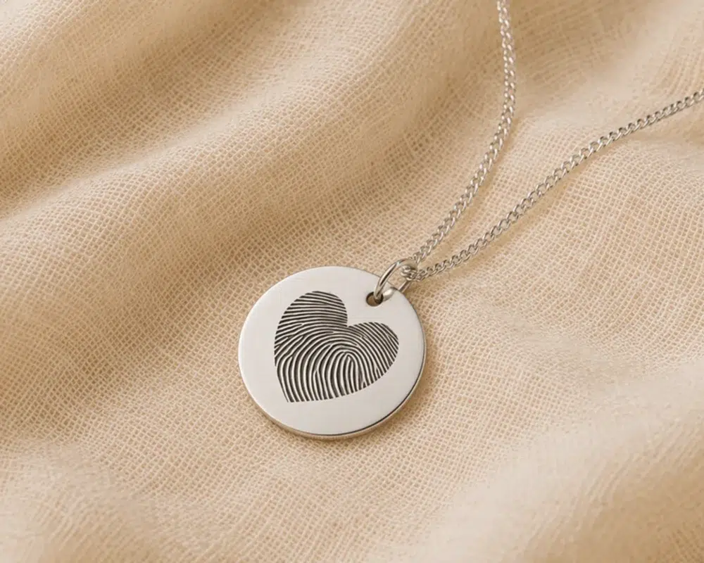 Silver disc necklace engraved with a heart shaped fingerprint