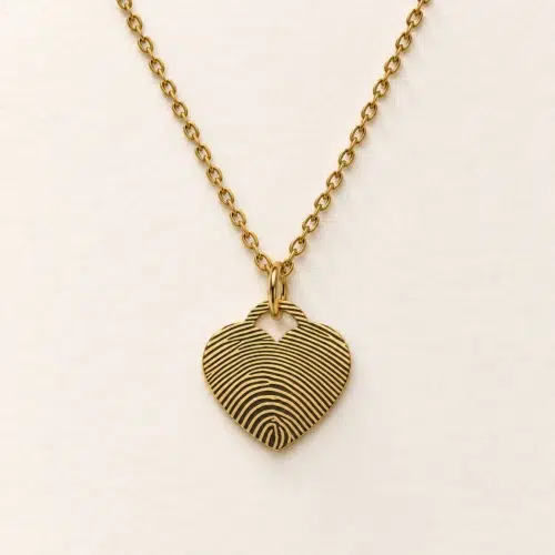 15mm gold coloured stainless steel heart necklace with fingerprint engraving on an ivory background