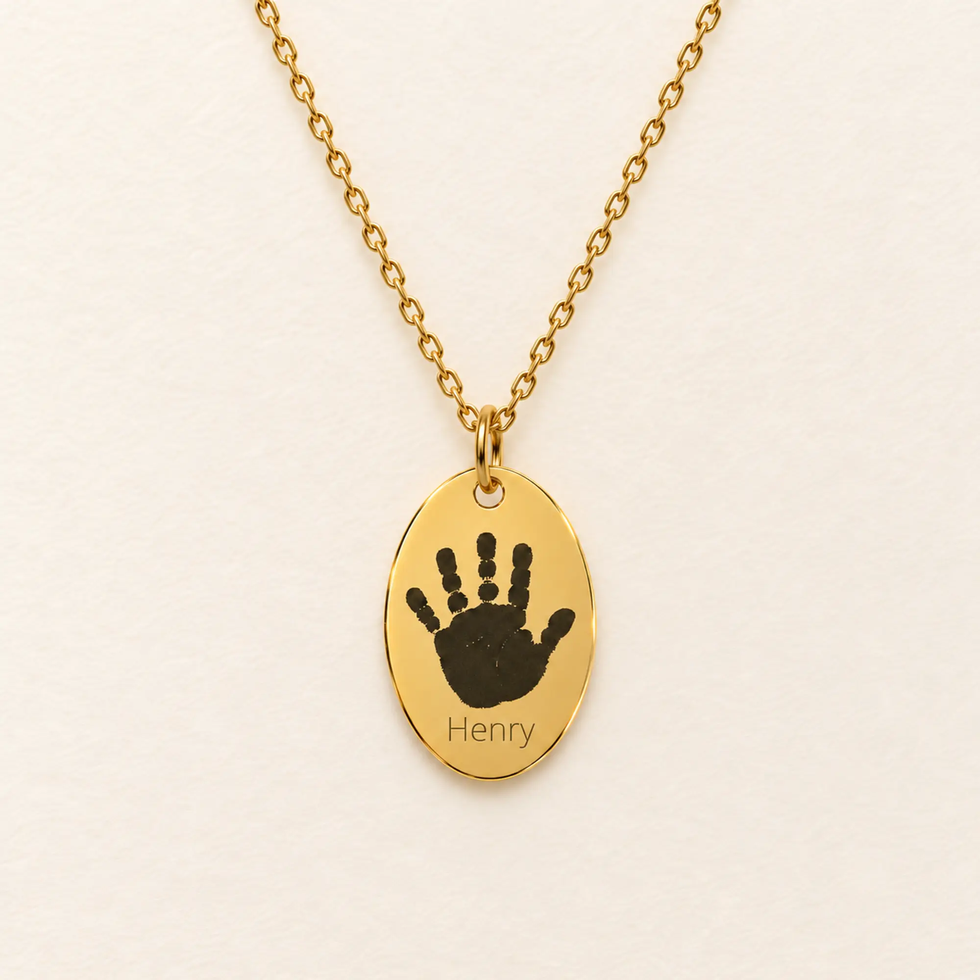 12x18mm gold coloured stainless steel oval necklace with a handprint.