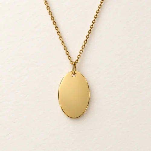 Plain 12 x 18mm gold coloured stainless steel oval necklace on a matching chain against a light textured background.