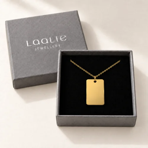 Plain 15 x 22mm gold coloured stainless steel rectangular necklace displayed in an open grey Laalie gift box.