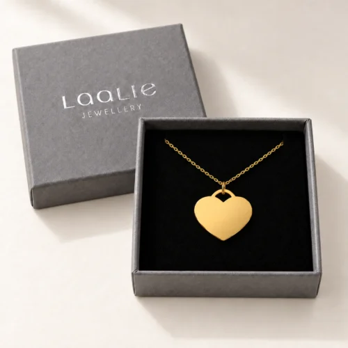Plain 20mm gold coloured stainless steel heart necklace displayed in an open grey Laalie gift box.
