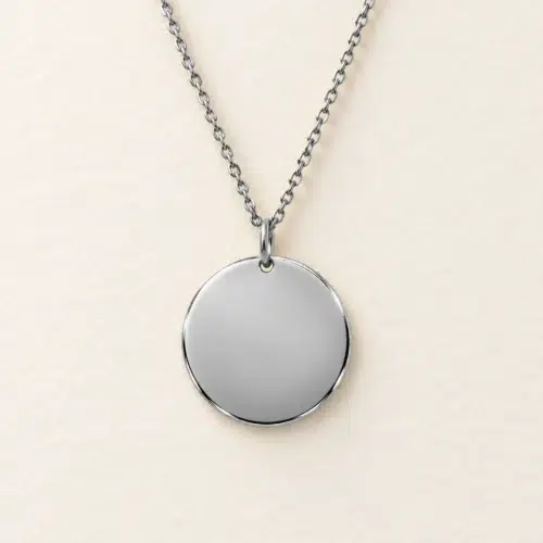 Plain 18mm silver coloured stainless steel disc necklace on a matching chain against a light textured background.