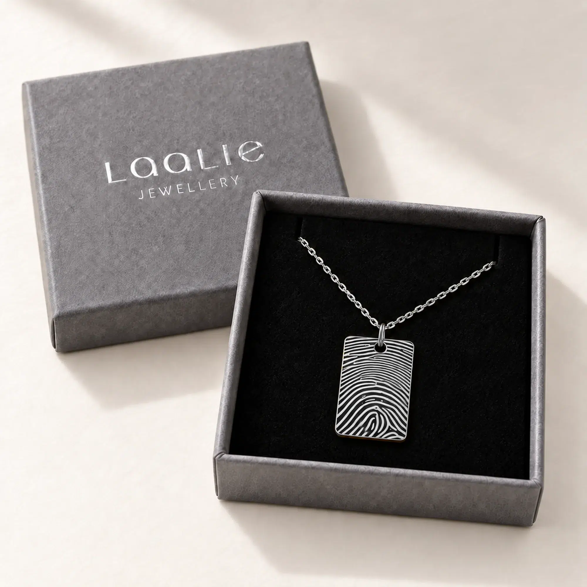 15 × 22mm silver coloured stainless steel fingerprint rectangle necklace in an open grey Laalie gift box